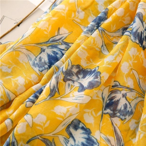 Close-up of lightweight lemon yellow cotton linen scarf with blue floral prints