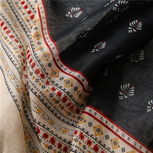 Close-up of black and beige ethnic pattern fabric with fine woven texture and tassels
