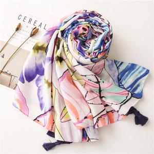 Detailed view of leaf pattern shawl featuring colorful butterflies and blue tassel fringe