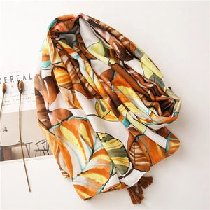 Detail of cotton scarf with orange butterfly wing patterns and dark brown tassel edges