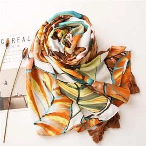 Colorful leaf pattern scarf with brown tassels on a soft minimalist background