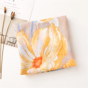 Detail of floral cotton linen scarf with orange blossoms and soft fringe edges