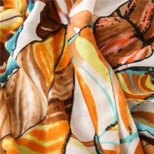 Close-up of vibrant butterfly print scarf fabric with orange and blue winged patterns