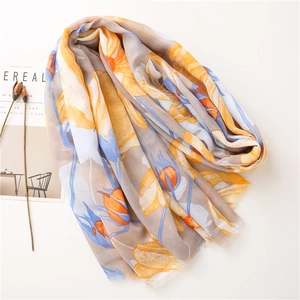 Detail of floral linen scarf with fringe edges and vibrant yellow and blue patterns
