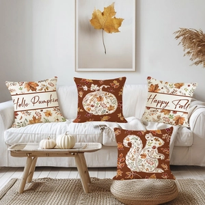 Set of four autumn throw pillow covers with pumpkin and maple leaf prints on a white sofa