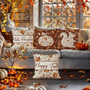 Set of four autumn throw pillow covers featuring maple leaves and pumpkins on a gray sofa