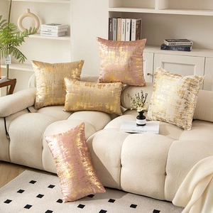 Velvet gold foil decorative pillows in pink and champagne on a modern sofa