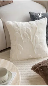 Close-up of modern beige plush pillow cover with embossed textured branch patterns
