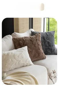 Close-up of plush throw pillows with textured leaf patterns on a modern sofa