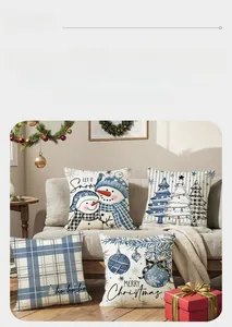 Detailed view of blue Christmas pillowcases with snowman and plaid prints on a grey sofa