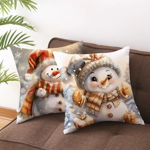 Set of two Christmas snowman pillow covers on a brown sofa with cozy festive home decor