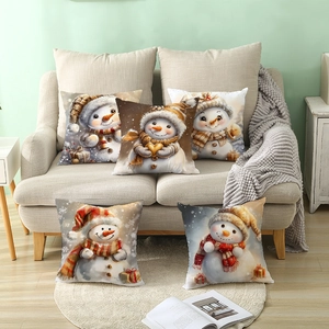 Set of 5 Christmas pillow covers with festive snowman prints on a cozy sofa