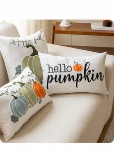 Vue détaillée de la broderie de citrouille d'automne sur des coussins beiges élégants