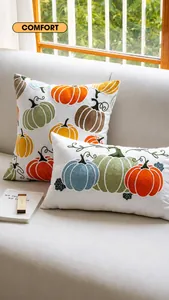 Gros plan de la broderie citrouille détaillée sur housse de coussin en lin blanc