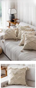 Close-up of tufted geometric patterns and handmade tassels on boho beige cushion covers