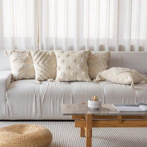 Bohemian cream throw pillow covers with textured tufted geometric patterns and fringe