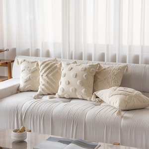 Bohemian cream cushion covers set with geometric tufted embroidery and fringe on sofa