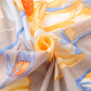 Close-up of linen scarf with abstract yellow and orange floral patterns and soft texture