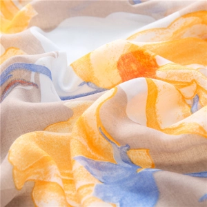 Macro detail of breathable linen-cotton floral scarf with vibrant yellow and blue prints