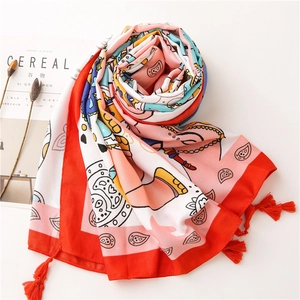 Detail view of colorful elephant print scarf featuring red tassel trim and soft fabric