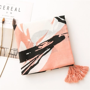 Detail of cotton linen scarf showing abstract pink and black print with delicate tassels