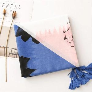 Close-up of abstract blue and pink linen scarf with elegant blue tassel trim details