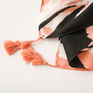 Detailed close-up of cotton linen scarf with color-block patterns and tassel accents