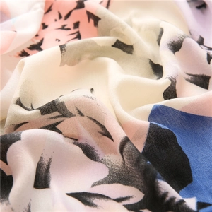 Close-up of soft linen cotton scarf fabric with pink and blue abstract floral print