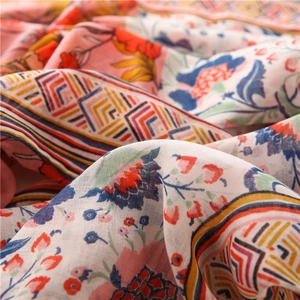 Macro view of floral and geometric ethnic print on soft coral pink cotton linen scarf