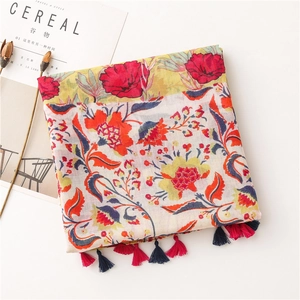 Close-up of lightweight floral cotton linen scarf featuring colorful patterns and tassels