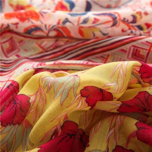 Detailed close-up of pink totem and red floral print on cotton linen scarf fabric