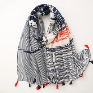 Detailed close-up of navy and orange striped cotton scarf with bohemian fringe tassels