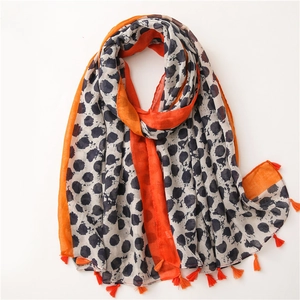 Détail d'une écharpe léopard avec des franges orange vif et des bords contrastés