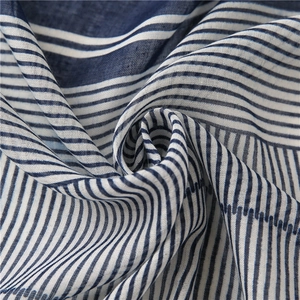 Close-up of blue and white striped cotton-linen fabric with soft spiral texture