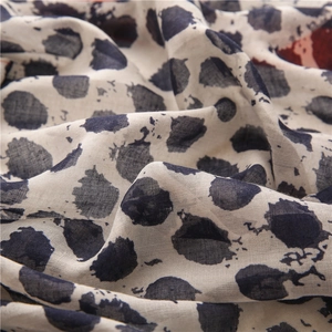 Vue macro de pois léopard bleus sur la texture en lin et coton d'une écharpe légère
