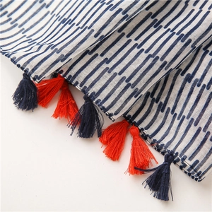 Macro shot of cotton linen scarf edge with navy stripes and colorful tassels