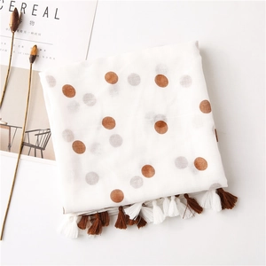 Detail of white cotton linen scarf with brown polka dots and fringe tassels