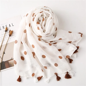 Detail of white cotton linen scarf with large brown polka dots and fringe tassels