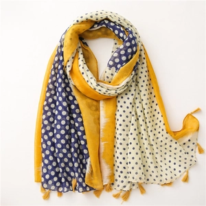 Detail of linen scarf with yellow tassels and contrast polka dot pattern in blue and beige