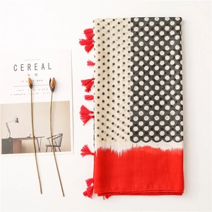 Detailed view of polka dot scarf with red tassels and soft cotton linen texture