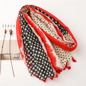 Detail of polka dot linen shawl with red tassels and soft geometric color blocking