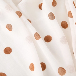 Macro shot of breathable cotton linen fabric with brown polka dots and soft texture