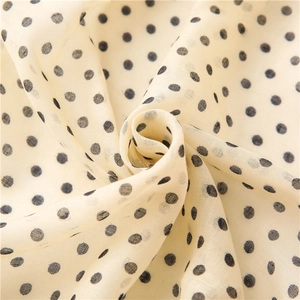 Close-up of soft beige cotton linen scarf with elegant black polka dot pattern details