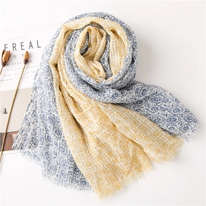 Detail of yellow and blue floral cotton scarf with soft frayed edges and breathable texture