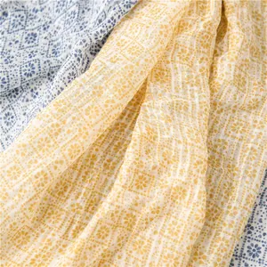 Close-up of lightweight cotton linen scarves with elegant blue and yellow floral prints