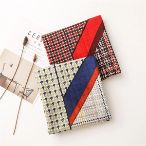 Detail of folded houndstooth scarves with geometric patterns and lightweight texture
