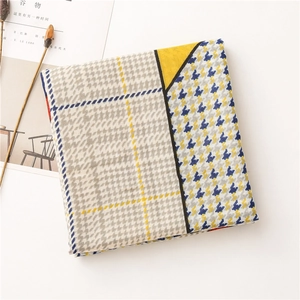 Detailed texture of patchwork houndstooth linen scarf with yellow and blue patterns