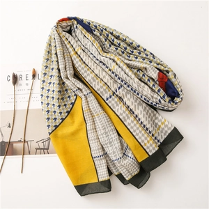 Detail of grey and yellow patchwork houndstooth cotton linen scarf with soft fringe