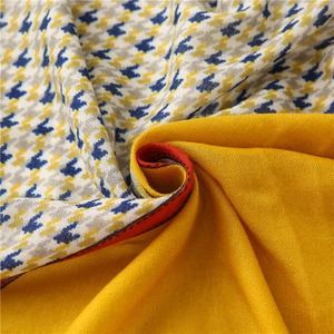 Detail of houndstooth weave in blue and yellow with contrast red stitching on the edge