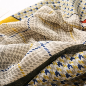 Detail shot of houndstooth scarf showing soft linen-cotton fabric texture in blue and yellow